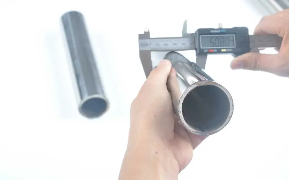 Caliper measuring the diameter of a polished stainless steel tube