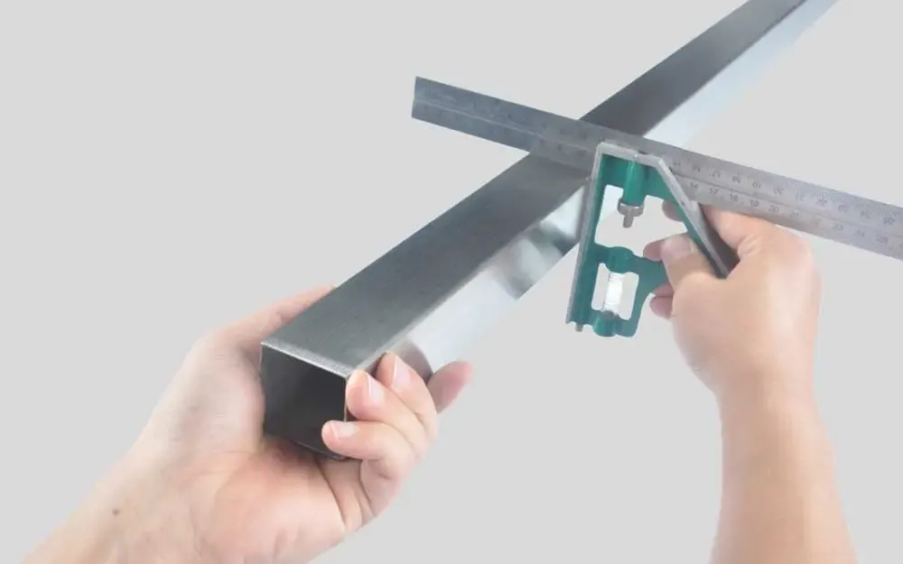 Measuring a rectangular stainless steel tube with a ruler
