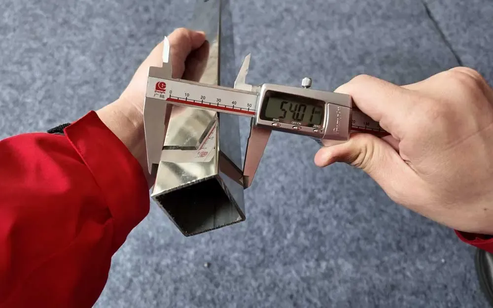Measuring a square stainless steel tube with a digital caliper