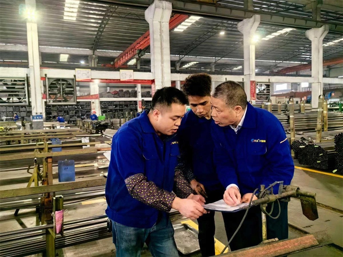 Production team reviewing stainless steel tube requirements